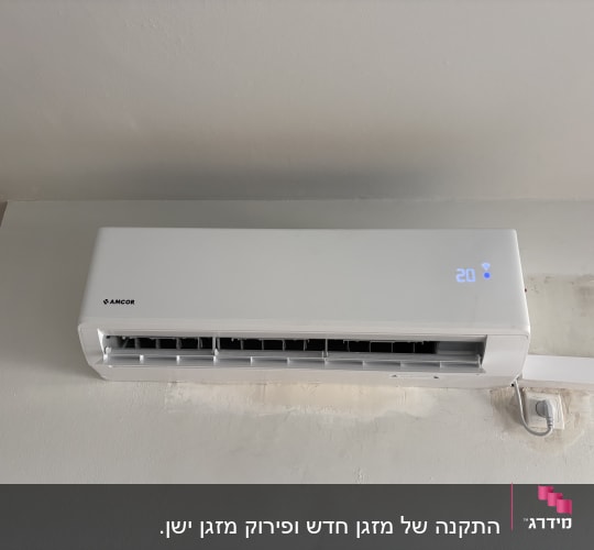 מזגן עילי לבן מותקן על קיר פנימי לאחר התקנה